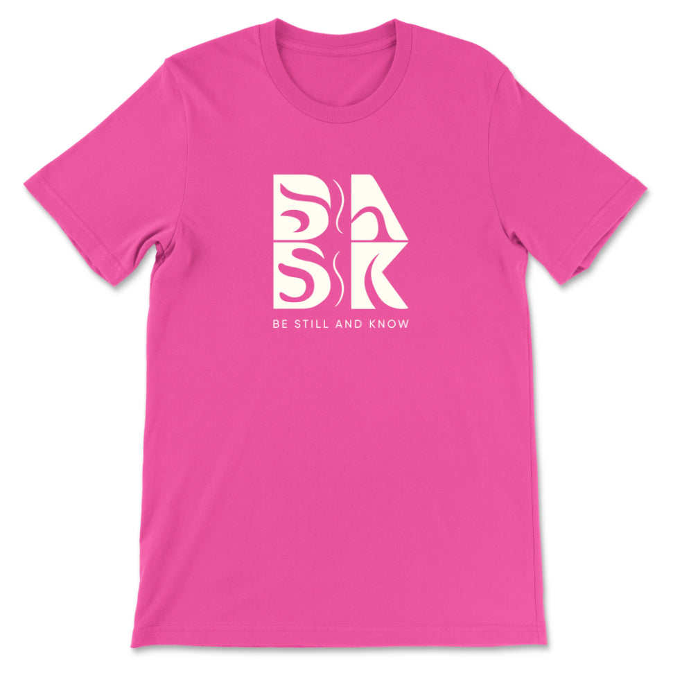 A Golden Coast Vibes Tee In Berry with the Be Still and Know logo and the word "bask" on it.
