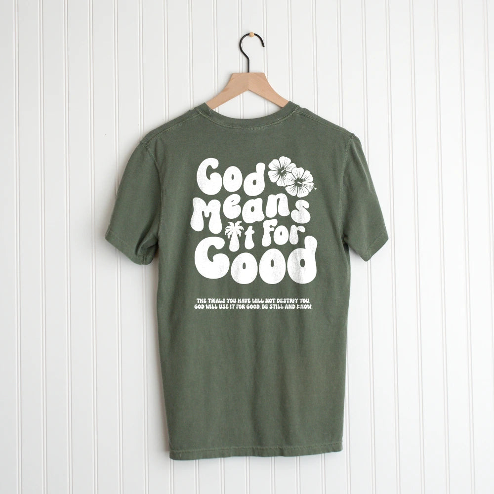 Green Be Still and Know God Means It For Good Shirt with "God grows new life" inspirational quote hanging on a wooden hanger against a white wall.