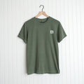 Olive green God Means It For Good Shirt with a small logo symbolizing 