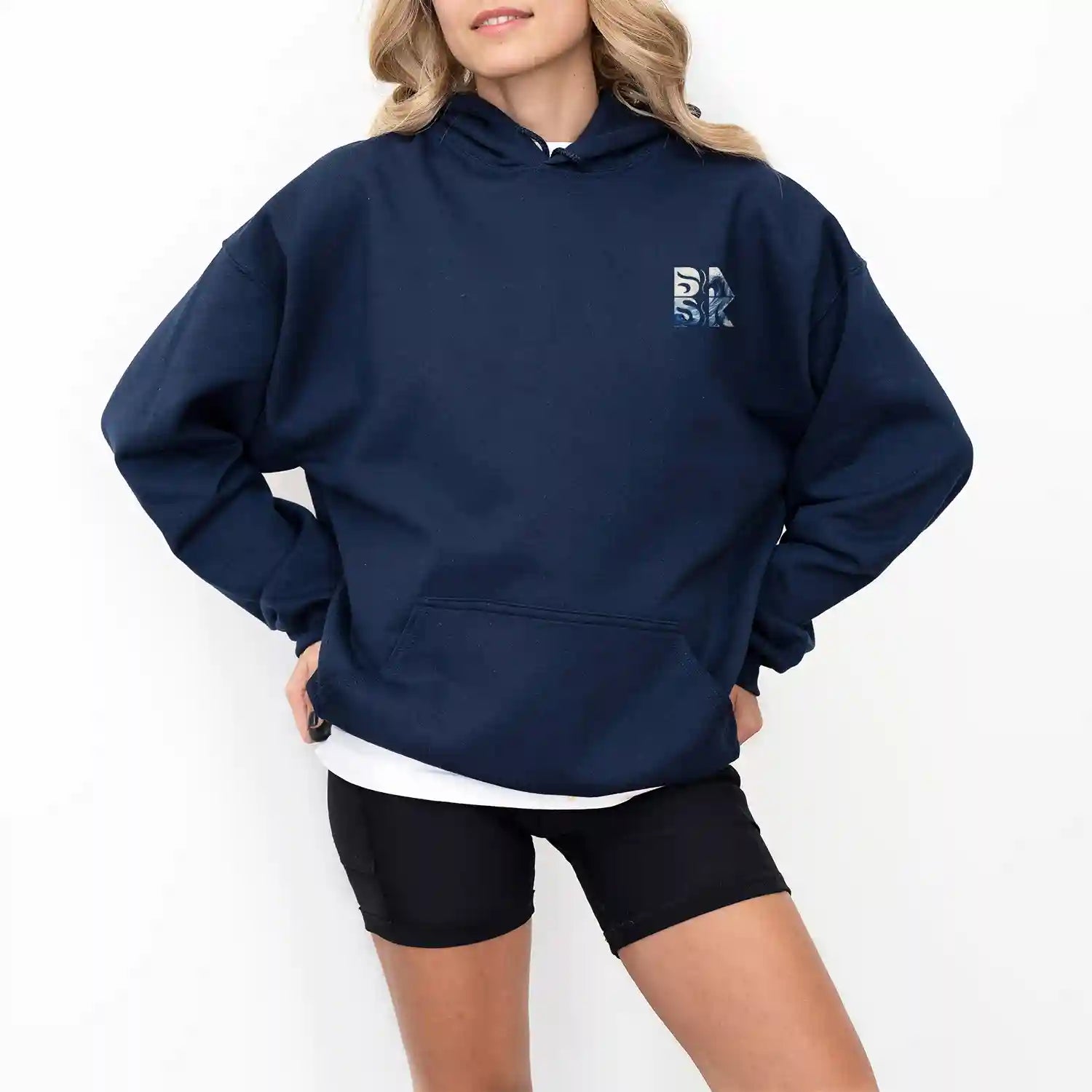 A woman wearing a navy Peace Be Still Hoodie and shorts showcasing Be Still and Know Apparel.