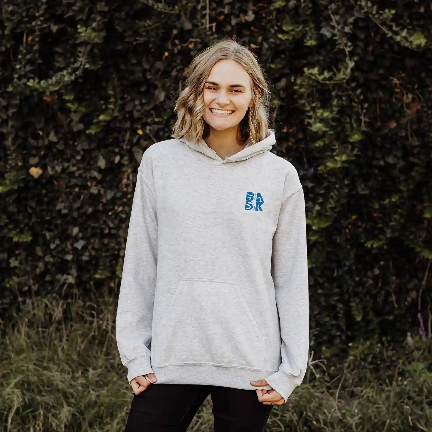 A woman wearing a Kupa'a Tide Hoodie by Be Still and Know.