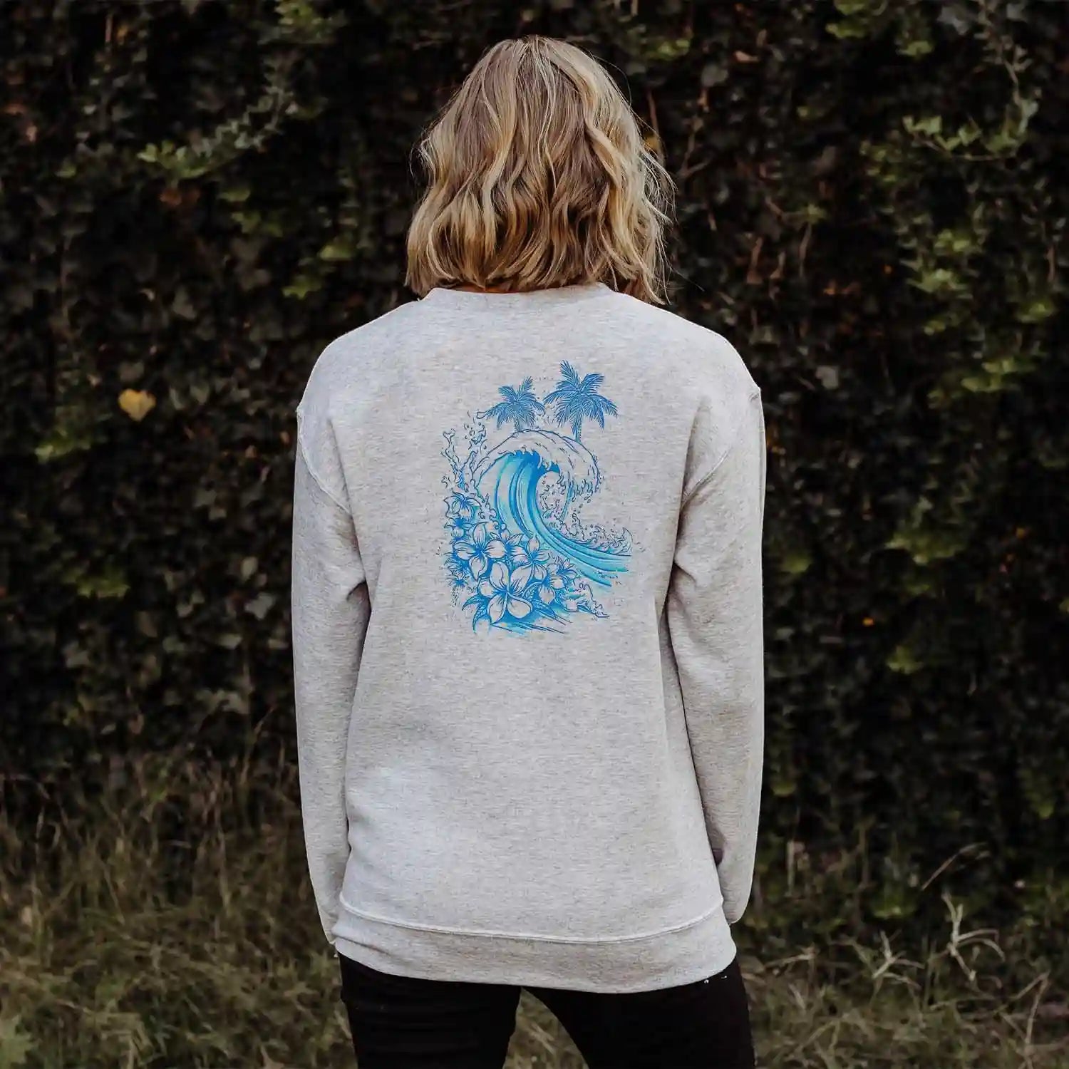 A person standing in front of a bush wearing Be Still and Know Christian apparel, specifically the Kupa'a Tide Sweatshirt.