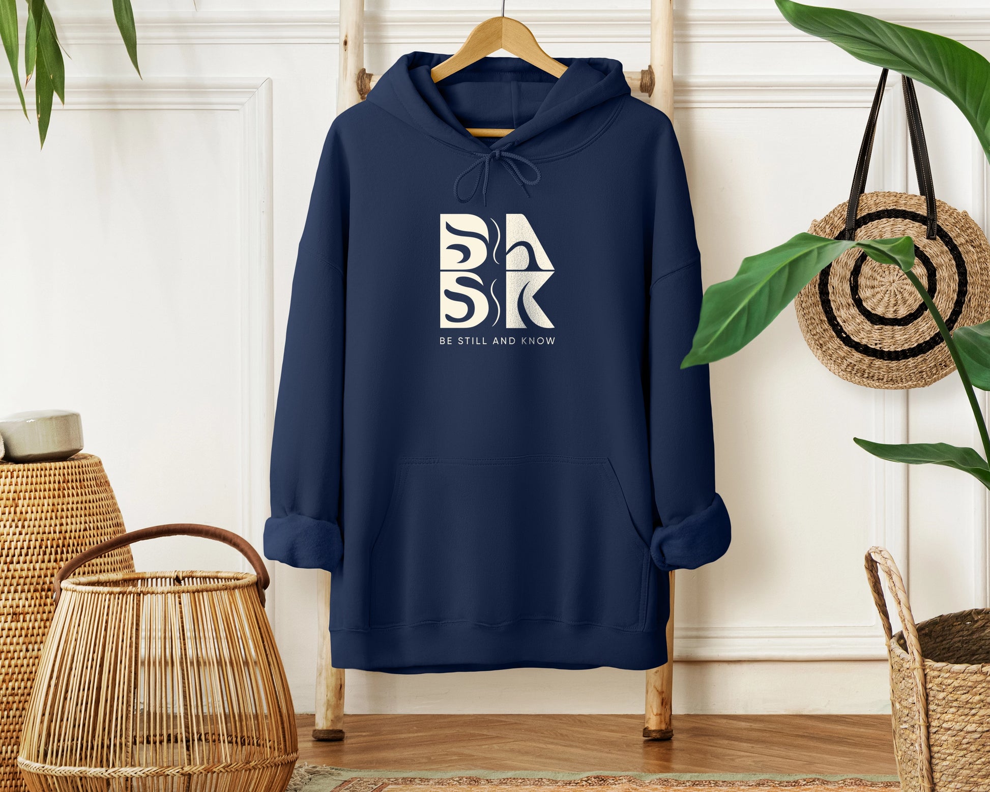 A Blessed Beginnings Hoodie In Navy with the Be Still and Know logo.