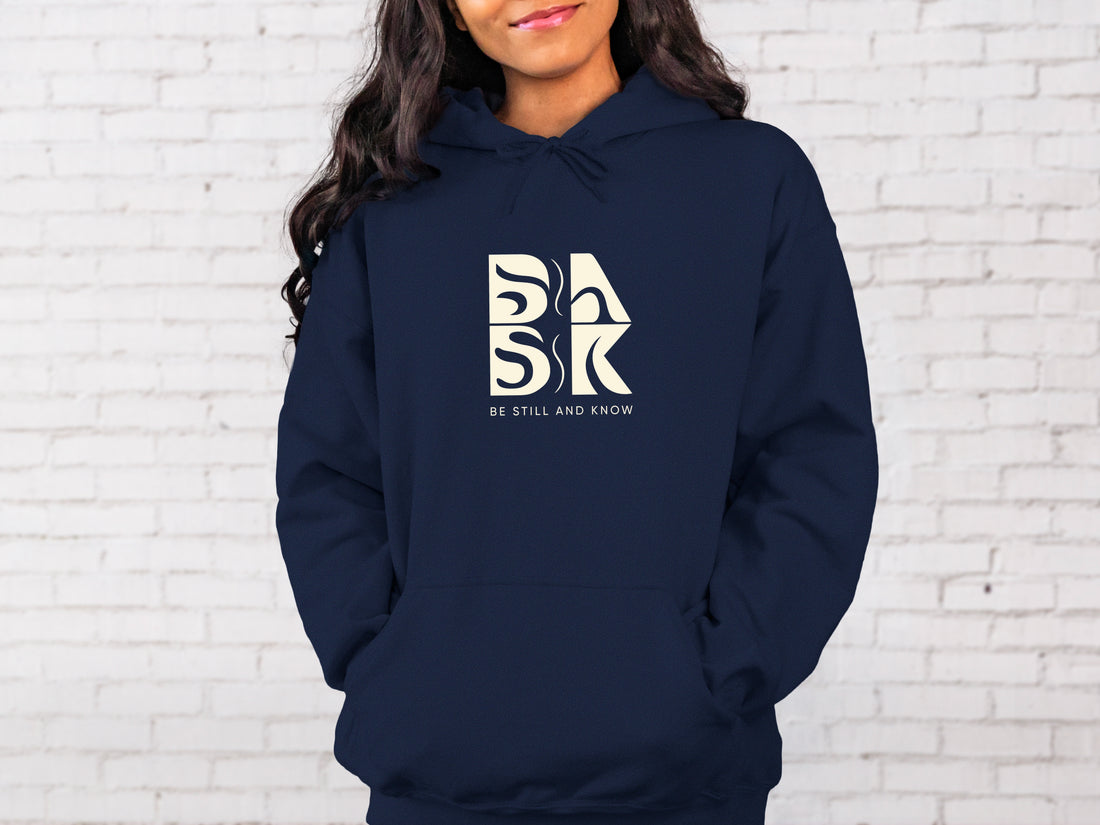 A Blessed Beginnings Hoodie In Navy with a Be Still and Know logo on it.
