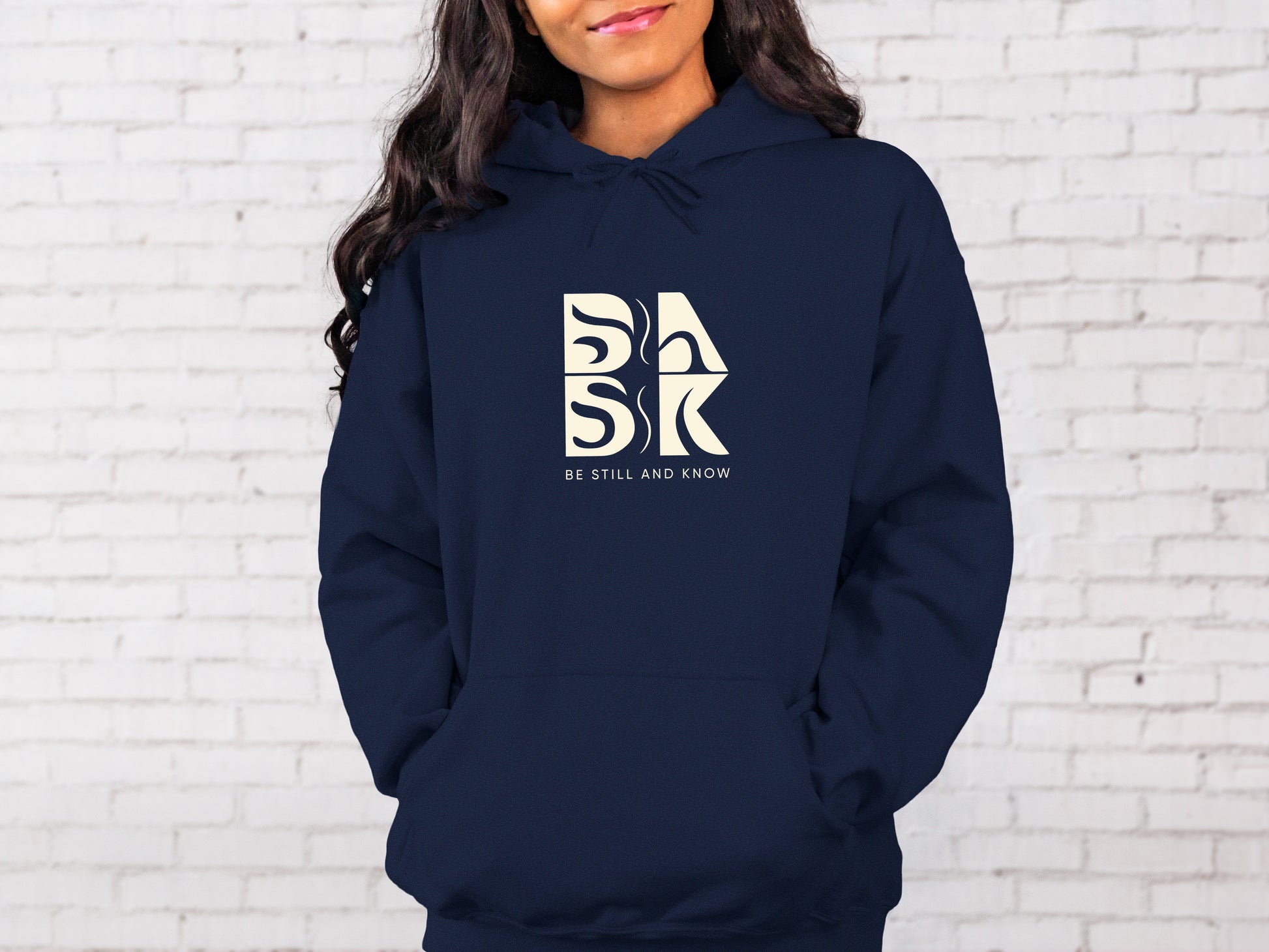A woman wearing a navy hoodie with the words "Blessed Beginnings Hoodie In Navy" on it, representing Christian Apparel by Be Still and Know.
