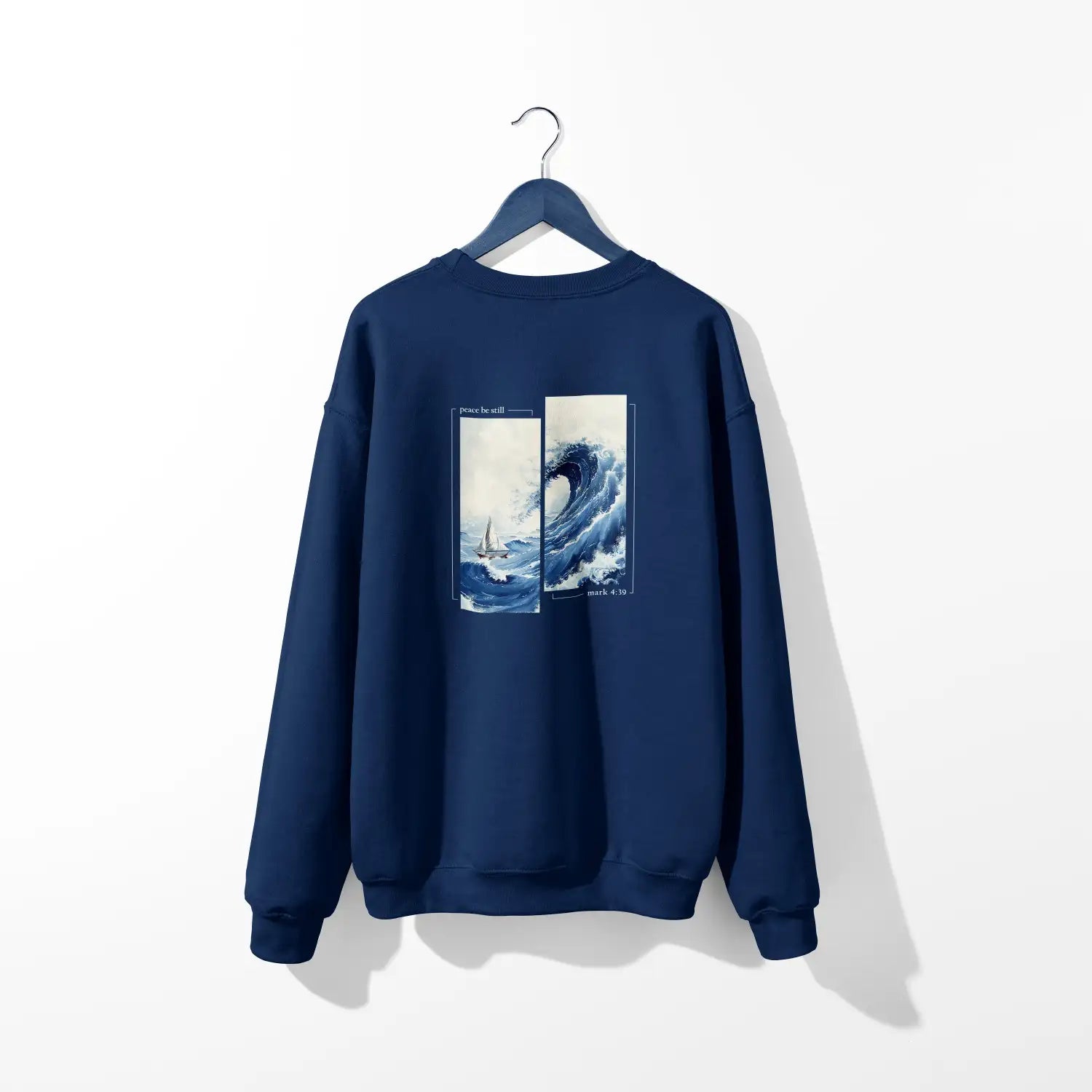 A Peace Be Still sweatshirt with an image of a wave on it, featuring the Be Still and Know Logo.