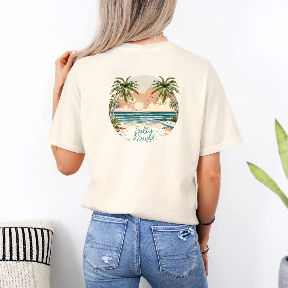 A woman from behind, wearing a beige Salty & Saved Shirt with a tropical beach design and blue jeans, standing in a room.