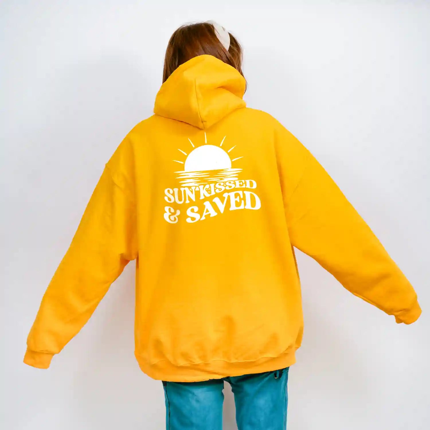 A woman wearing a Sunkissed & Saved Hoodie from Be Still and Know looks sunkissed.
