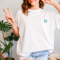 Woman in a Be Still and Know Spirit Lead Me Shirt, radiating self-reliance, flashing a peace sign.