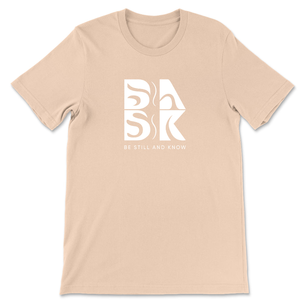 A Coastal Calm Tee In Sand Dune featuring the Be Still and Know logo, perfect for those looking for Christian clothing.