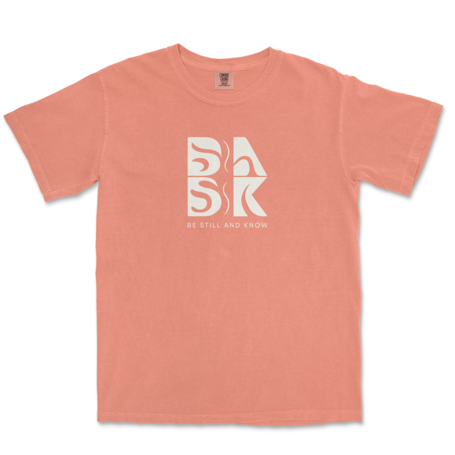 An Aloha Tee In Terracotta with the word "bak" on it, showcasing the Be Still and Know logo.
