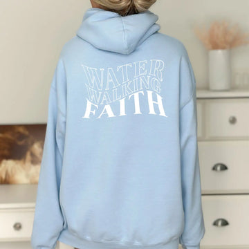 A woman wearing a Be Still and Know Water Walking Faith Hoodie.