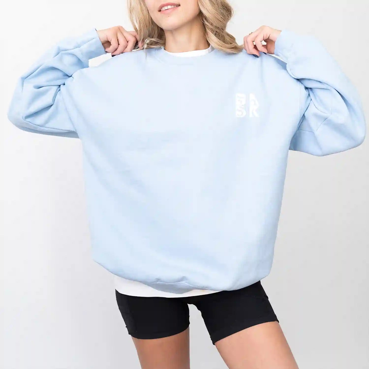 A woman wearing a light blue Water Walking Faith Sweatshirt and Be Still and Know clothing.