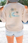 The back of a woman wearing a Be Still and Know Nalu o ka Mana (Waves of Faith) Sweatshirt with palm trees.